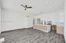 Open-concept interior featuring wood-finish flooring, recessed lighting, and a kitchen equipped with quartz countertops, two-tone cabinetry, and stain