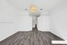 Room featuring high vaulted ceilings, wood-finish flooring, and a textured drum pendant light fixture