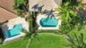 Aerial perspective featuring two outdoor swimming pools, paver decking, lush perimeter landscaping, and tile roofing