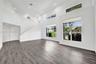 High-ceilinged interior featuring wood-finish flooring, recessed lighting, and multi-level windows