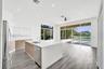 Kitchen featuring wood-finish cabinetry, white countertops, stainless steel appliances, wood-finish flooring, and expansive glass sliding doors