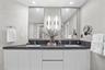 A private spa within the primary suite, this exquisite bathroom showcases custom porcelain tile, a frameless glass shower, a freestanding soaking tub 