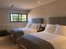 Neutral-toned room featuring recessed ceiling lighting, textured wall coverings, and a multi-pane window with black framing