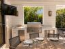 Covered outdoor kitchen featuring shiplap siding, built-in stainless steel grill, stone countertops, dual under-counter stainless steel appliances, an