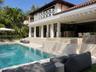 Exterior terrace featuring a swimming pool, integrated spa, covered patio with recessed lighting, and a second-level balcony with white lattice railin