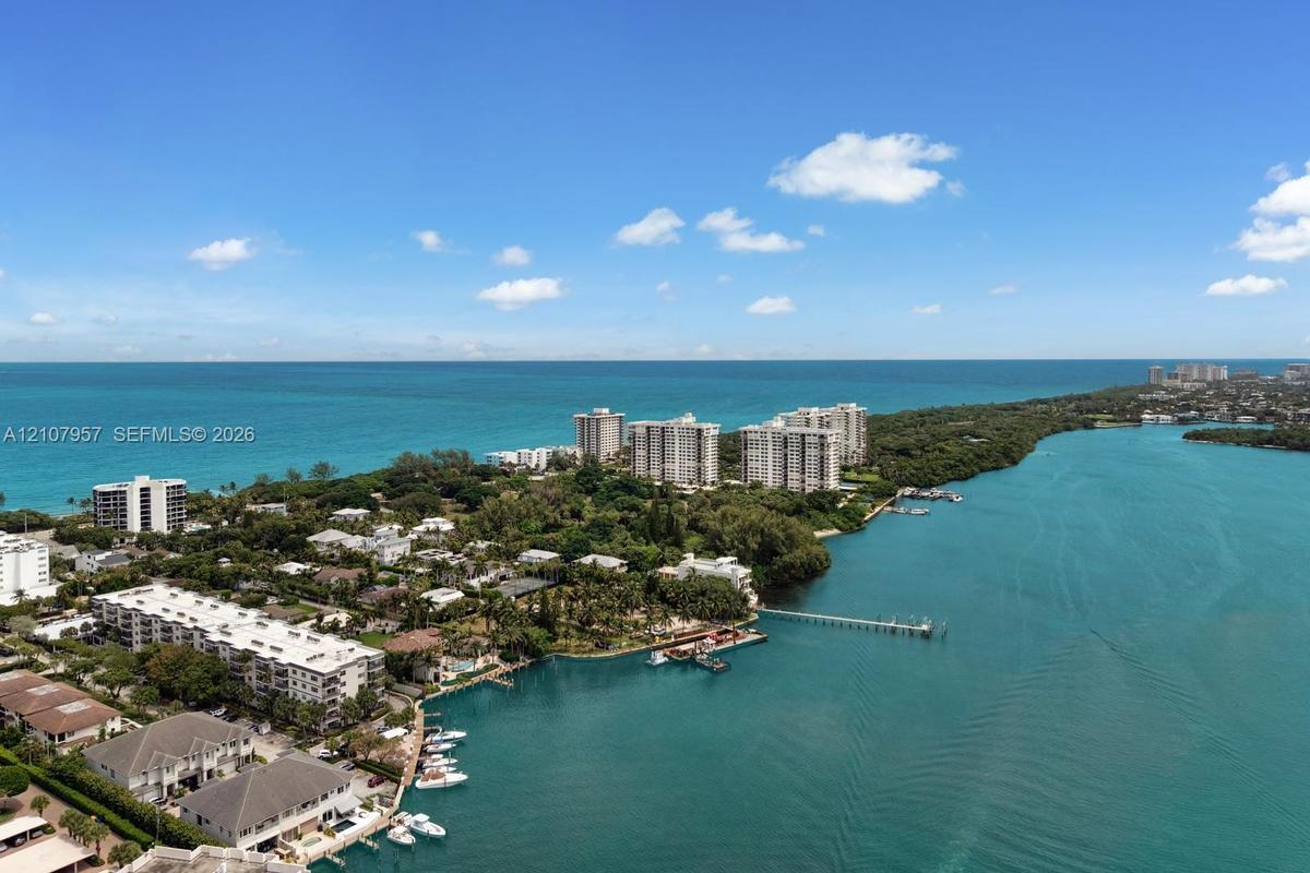 Aerial perspective of coastal landscape featuring turquoise waters, mature vegetation, and extensive shoreline
