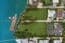Waterfront parcel featuring extensive shoreline, a private deep-water dock, mature palm landscaping, and expansive green space