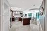 Kitchen featuring dark wood-finish cabinetry, quartz countertops, stainless steel appliances, recessed lighting, and tile flooring