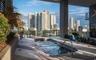Covered terrace featuring a custom spa, tile flooring, glass panel railings, and perimeter landscaping