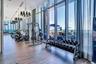 Fitness facility featuring floor-to-ceiling windows, wood-finish flooring, and industrial-style multi-arm chandeliers
