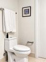 High-efficiency one-piece toilet featuring polished chrome hardware and neutral tile flooring