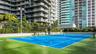 Tennis court with high-contrast dual-tone hard surfacing, perimeter chain-link fencing, structural pergola, and integrated lighting