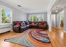 Hardwood flooring throughout, crown molding, double-hung windows, arched entryway, and a hanging light fixture