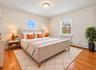 Hardwood flooring, two windows with blinds, and white walls