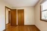 Hard wood flooring, wood-framed window with integrated roller shade, wood-finish interior doors, and a reach-in closet.
