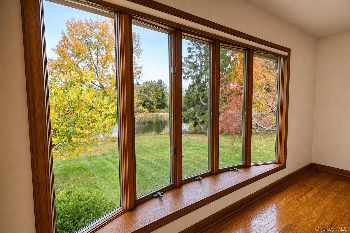 Bow window overlooking front yard and private stocked pond