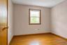 Room featuring hard wood flooring, neutral wall paint, and a single-hung window with wood trim