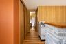Family room hallway with dual sliding door storage closet and entrance to the half bath