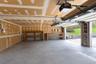 Two-car garage featuring a concrete floor, built-in wooden shelving, and a ceiling-mounted automatic garage door opener