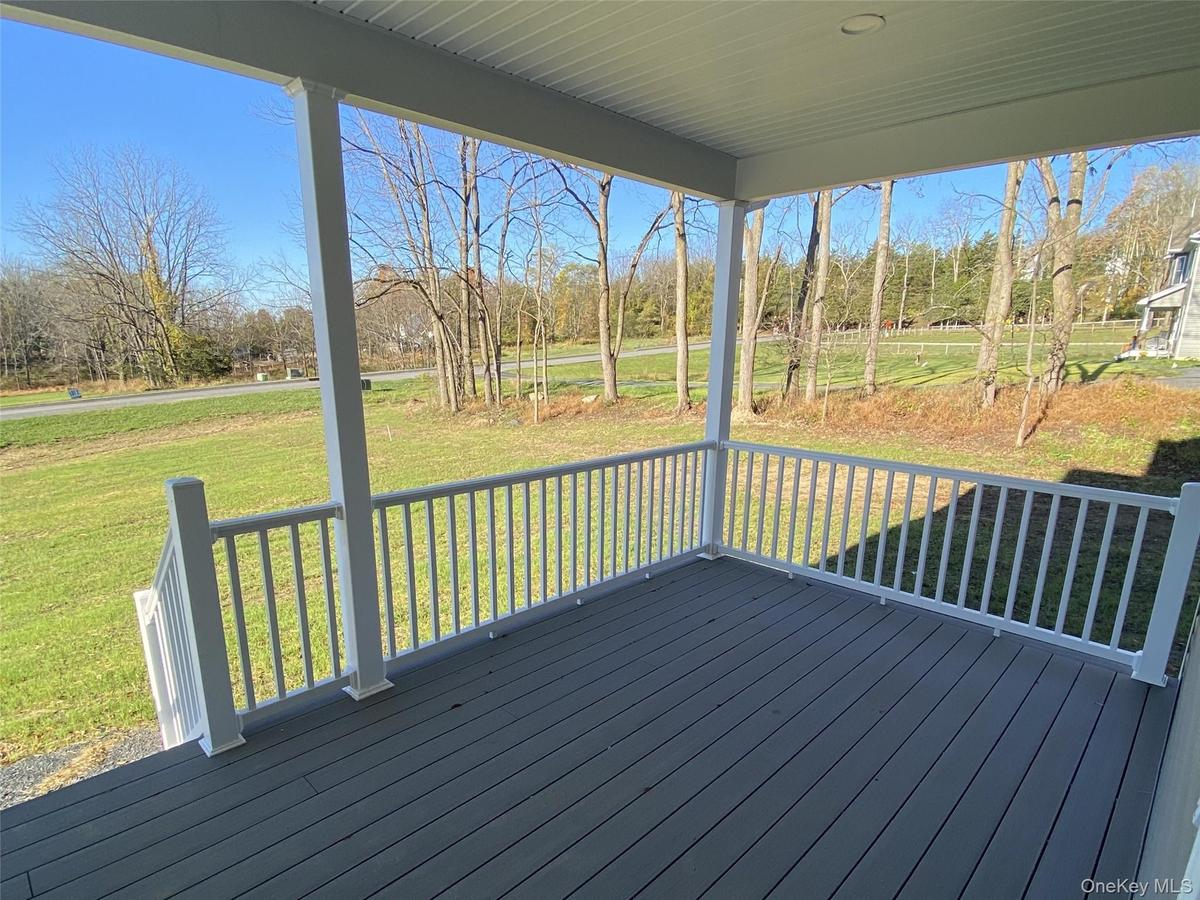 Covered porch features views of the expansive yard and surrounding landscape