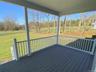 Covered porch features views of the expansive yard and surrounding landscape