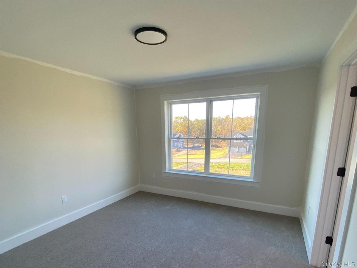 Bedroom finish work is nearing completion with newly installed carpet.