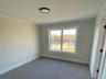 Bedroom finish work is nearing completion with newly installed carpet.
