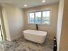 Enjoy the beauty and convenience of the newly installed free standing soaking tub beneath a window to create an inviting space.