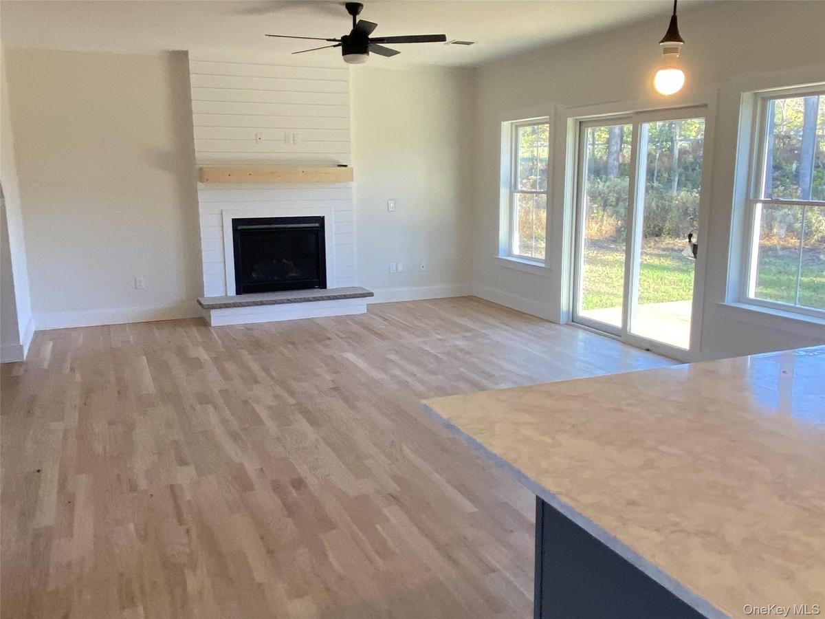 An additional view of the open living spacehighlighting the fireplace and sliding glass doorsleading outdoors.