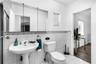 Pedestal sink with dual-handle faucet, wall-mounted medicine cabinet with mirror, decorative mosaic tile backsplash, and full-wall ceramic tile surrou