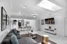 Spacious interior featuring ceramic tile flooring, a large skylight, ornate ceiling medallions, recessed lighting, and chair rail molding