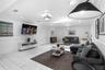 Spacious room featuring tile flooring, crown molding, chair rail trim, recessed lighting, and a skylight