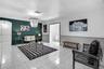 Interior room featuring large-format tile flooring, crown molding, chair rail trim, and a multi-tiered beaded pendant light fixture