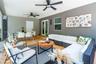 Covered patio featuring ceramic tile flooring, dual ceiling fans, and glass-paned double doors
