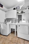 Utility room featuring white cabinetry, a deep basin sink with a chrome faucet, open shelving, and ceramic tile flooring