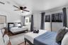 Room featuring tile flooring, a multi-blade ceiling fan, sliding glass doors, and dual-pane windows