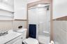 Bathroom featuring a walk-in shower with a glass sliding door, molded shower surround, recessed ceiling lighting, and a pedestal sink