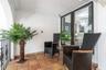Covered balcony featuring terra-cotta tile flooring, wrought-iron railing, and large-format glass paneled doors