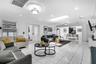 Open-concept living space featuring large-format tile flooring, multiple recessed light fixtures, a prominent skylight, ceiling-mounted decorative lig