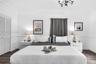 Bedroom featuring wood-finish flooring, crown molding, chair rail trim, louvered closet doors, and an ornate crystal chandelier