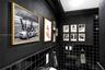 Interior wall featuring matte black wall paint, black square-tiled wainscoting, and crown molding