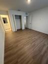 Wood-finish flooring, neutral wall tones, interior closet with shelving, and multi-panel interior door