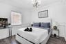 Wood-finish flooring, crown molding, wainscoting, and an ornate multi-arm chandelier