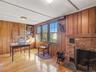 Bedroom or office space with hardwood floors and a wood-burning fireplace.