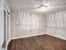 Room featuring wood-finish flooring, square crystal-accented flush mount ceiling light, and double doors with glass inserts