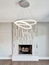 Contemporary circular pendant lighting, full-height vertical stone tile fireplace surround, exposed brick firebox, and solid stone hearth