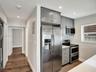 Kitchen featuring grey shaker-style cabinetry, stainless steel side-by-side refrigerator, double wall oven, quartz countertops, and recessed lighting
