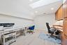 Skylight, wood-finish flooring, recessed lighting, and wall-to-wall built-in cabinetry with under-cabinet lighting