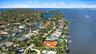 Waterfront property featuring a canal-side bulkhead, multi-level architectural design, and mature coastal landscaping