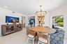 Dining area featuring recessed lighting, a multi-tiered brass chandelier, built-in recessed shelving with integrated lighting, and neutral large-forma